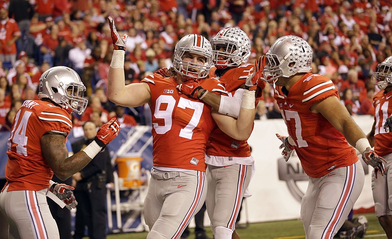 
              FILE - In this Dec. 6, 2014, file photo, Ohio State defensive lineman Joey Bosa (97) is congratulated by teammates after recovering a fumble and running it back for a touchdown during the first half of the Big Ten Conference championship NCAA college football game against Wisconsin in Indianapolis. Ohio State has suspended All-America defensive end Joey Bosa, receiver Corey Smith and H-backs Jalin Marshall and Dontre Wilson for its opening game at Virginia Tech. In a statement released about an hour before Big Ten media days began Thursday, July 30, 2015, the Buckeyes said the players violated department of athletics policy. (AP Photo/Michael Conroy, File)
            