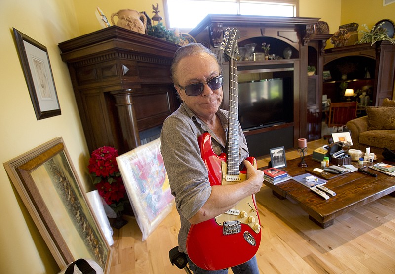 
              In this, Wednesday, July 22, 2015 photo, 1970’s heartthrob David Cassidy holds one of his favorite guitars as he gives a tour of his five-bedroom Florida mansion in Fort Lauderdale, Fla. Cassidy, 65, is auctioning the waterfront home and all its furnishings Sept. 9 as part of bankruptcy and divorce proceedings. The pianos and guitars displayed throughout his home won’t be included in the auction, as he’s working on a Christmas album and an album of songs he learned from his father, actor and singer Jack Cassidy. (AP Photo/Wilfredo Lee)
            