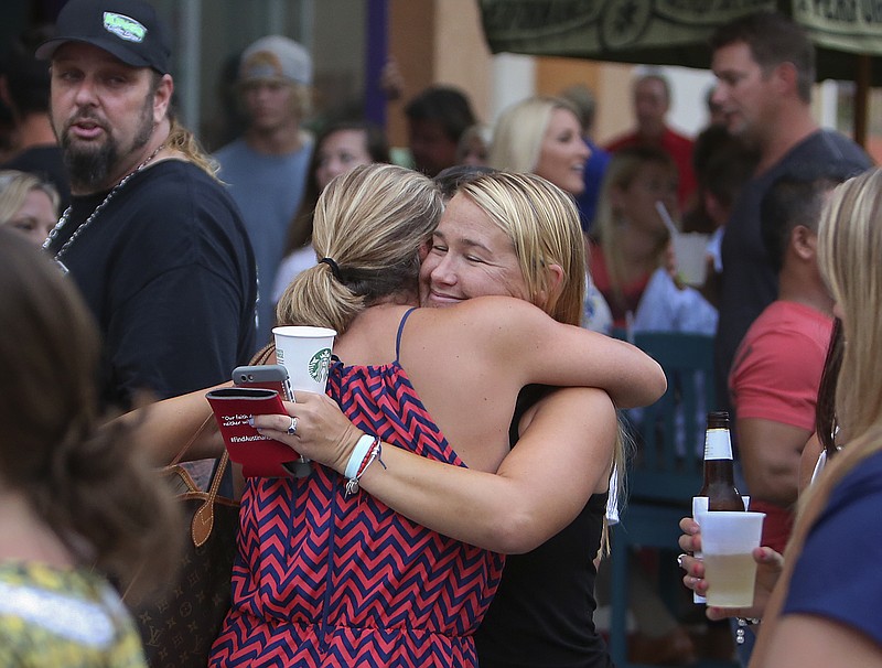 Carly Black, right, mother of Austin Stephanos, gets a hug at Jumby Bay Island Grill, Wednesday, July 29, 2015, in Jupiter, Fla., during a fundraiser to pay for the private search efforts for Nick Cohen and Austin Stephanos, who have been missing since they took their boat out of the Jupiter Inlet, Friday.