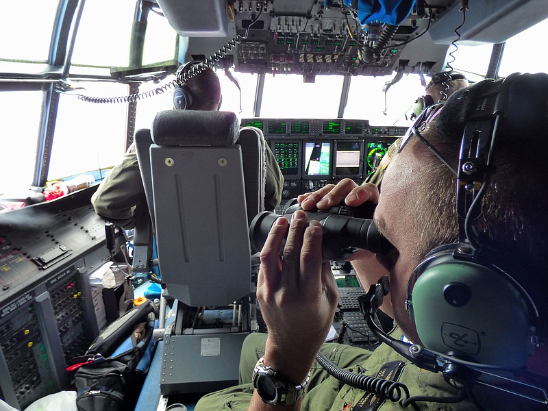 
              In this image released by the U.S. Coast Guard, Petty Officer 1st Class Mike Crosby, right, scans the surface of the Atlantic Ocean through his binoculars while in the cockpit of a Coast Guard HC-130J, Tuesday, July 28, 2015, while searching for Florida teens Perry Cohen and Austin Stephanos, Tuesday, July 28, 2015. The Coast Guard pressed ahead with a fifth day of searches for the boys while their families coordinated air searches of their own. (Senior Chief Petty Officer Sarah B. Foster/U.S. Coast Guard via AP)
            