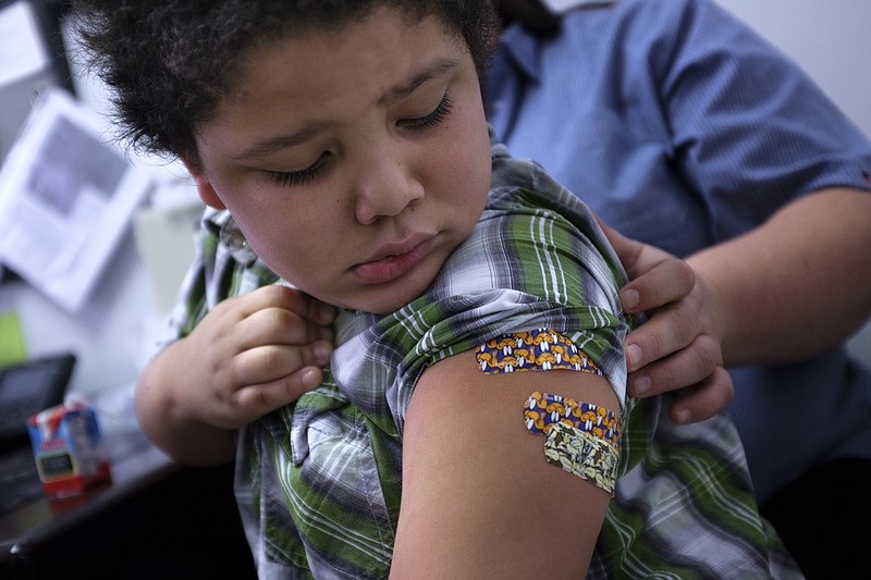 Treyveon Bradley, 5, checks his arm where after receiving his pre-kindergarden immunizations at the Hamilton County Health Department on Wednesday, July 29, 2015, in Chattanooga, Tenn. The health department is experiencing an influx of patients as parents vaccinate their children to prepare for the start of the school year.