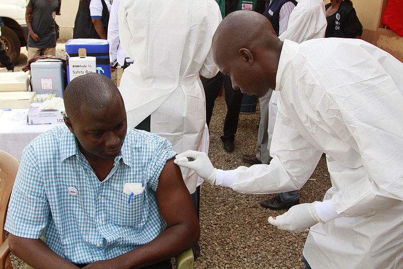 
              FILE - In this March 7, 2015 file photo, a health worker, right, cleans a man's arm before injecting him with a Ebola vaccine  in Conakry, Guinea. An experimental vaccine tested on thousands of people in Guinea exposed to Ebola seems to work and might help shut down the ongoing epidemic in West Africa, according to interim results from a study published Friday, July 31, 2015. There is currently no licensed treatment or vaccine for Ebola, which has so far killed more than 11,000 people in West Africa since the world’s biggest outbreak began last year.  (AP Photo/ Youssouf Bah, File)
            