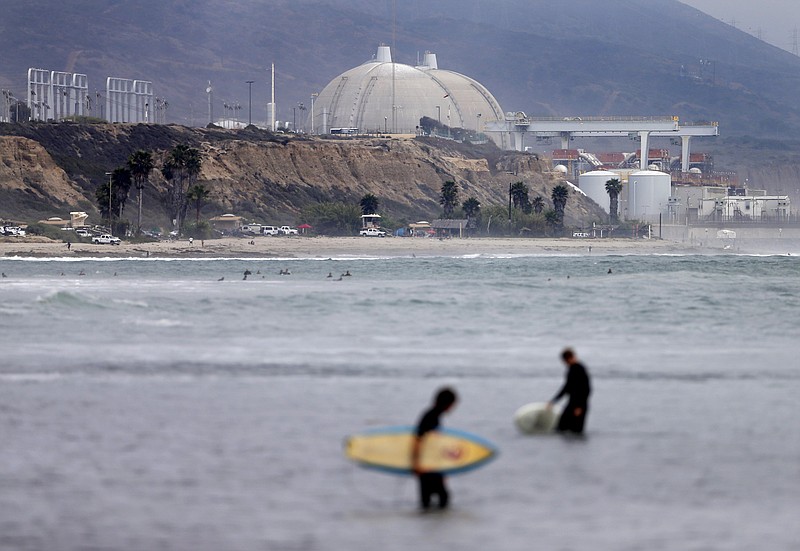 
              FILE - In this June 7, 2013 file photo, surfers pass in front of the San Onofre nuclear power plant in San Onofre, Calif.  Federal regulators have closed a case that questioned whether Southern California Edison violated government rules when it installed faulty equipment at the now-closed San Onofre nuclear power plant. (AP Photo/Gregory Bull, File)
            
