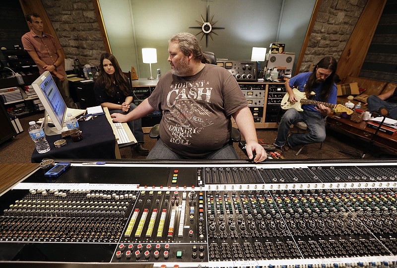 T. W. Cargile runs the sound board as Leroy Powell, right, plays the guitar during a recording session in RCA Studio A on Aug. 8, 2014, in Nashville.