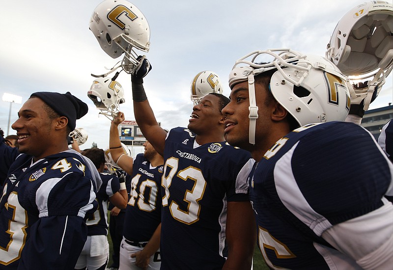 UTC defensive back Lucas Webb, defensive lineman Keionta Davis, and wide receiver C.J. Board, from left, celebrate their Southern Conference football win over Wofford in this 2013 file photo.
