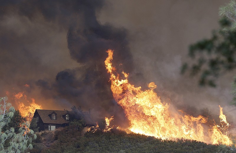 
              Fires approach a home near Lower Lake, Calif., Friday, July 31, 2015. A series of wildfires were intensified by dry vegetation, triple-digit temperatures and gusting winds. (AP Photo/Jeff Chiu)
            