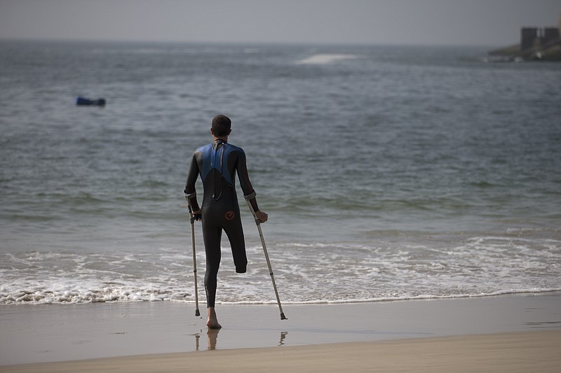 
              Paratriathlete stands on the shore of the Copacabana Beach during a training session, in Rio de Janeiro, Brazil, Friday, July 31, 2015. The Brazilian government's data on water pollution in Rio de Janeiro show water near where triathletes are preparing to compete this weekend is "unfit" for swimming. The most recent pollution reading at Copacabana was taken from a sample this past Monday. An Olympic qualifier and Paratriathlon event begins Saturday, and several athletes were already getting into the water Friday morning. (AP Photo/Silvia Izquierdo)
            