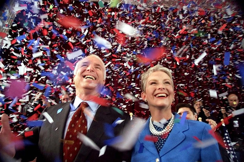 
              FILE  - In this Jan. 30, 2000, file photo, then-Republican presidential candidate Sen. John McCain, R-Ariz., and his wife Cindy, smile as confetti falls on them at the end of their 114th New Hampshire town hall meeting with voters at the Peterborough Town House in Peterborough, N.H. Peterborough was the sight of McCain's first town hall meeting in April 1999.  It was the summer of 1999, and McCain didn’t have many big names on the side of his campaign for president. He didn’t have much money or decent crowds, and even resorted at one point to giving away ice cream to lure voters to an event. Enter the town hall. McCain will be back in New Hampshire on Aug. 1 campaigning for friend and fellow Sen. Lindsey Graham at a town hall. (AP Photo/Stephan Savoia, File)
            