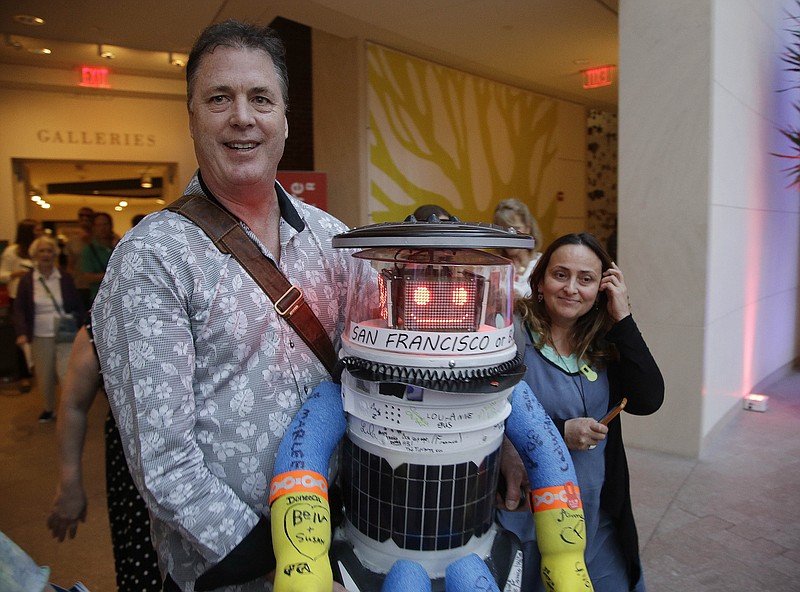 Co-creator David Harris Smith carries hitchBOT, a hitchhiking robot, during its' introduced to an American audience at the Peabody Essex Museum on July 16, 2015, in Salem, Mass.