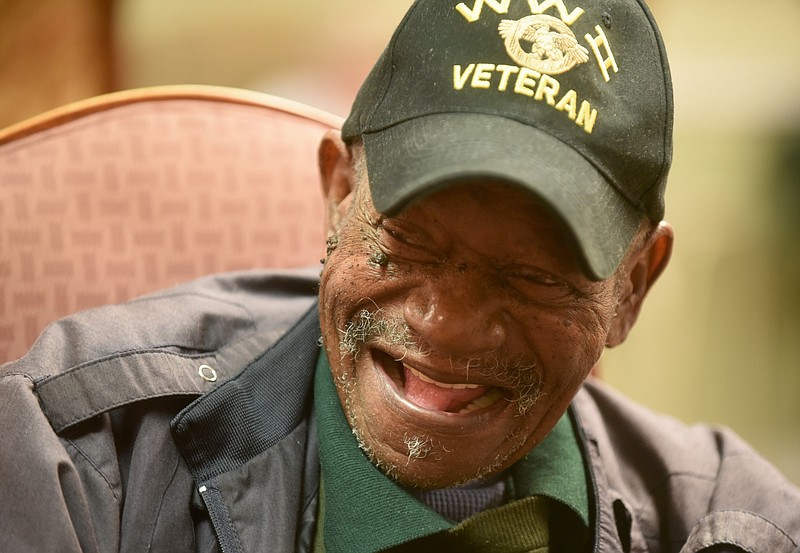 World War II veteran Curtis Sledge smiles while playing dominoes July 2 at Sharon's Adult Day Center.