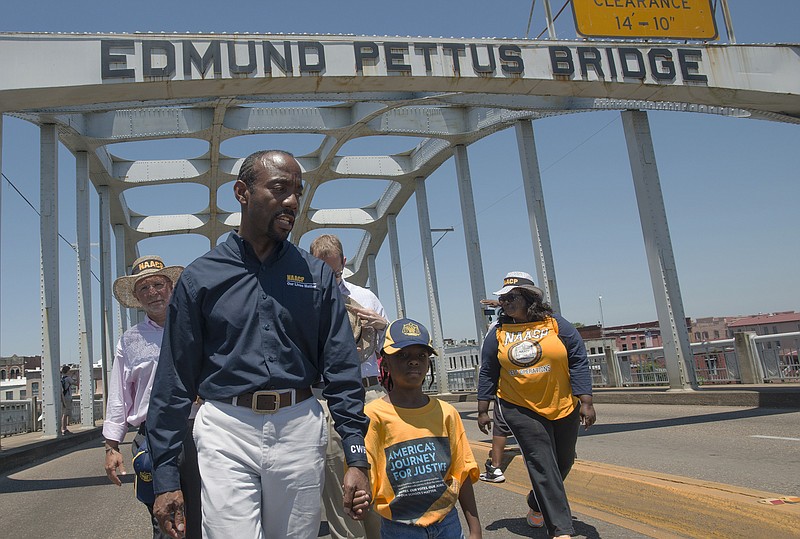 
              Cornell William Brooks, NAACP president, holds the hand of Rachel Quarterman, 7, while leading the "America's Journey for Justice March" organized by the NAACP on Saturday, Aug. 1, 2015, in Selma, Ala. The 860 mile relay march is planned to go from Selma to Washington D.C. over the course of 40 days. (Albert Cesare/Montgomery Advertiser via AP)
            