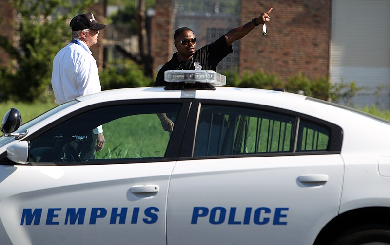 Memphis police canvas an area on Sunday, Aug. 2, 2015, near where Police Officer Sean Bolton was fatally shot during a traffic stop Saturday, in Memphis.
