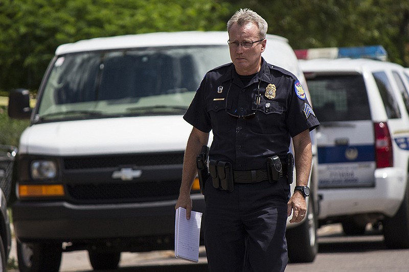 Phoenix police officers work outside a home where they found a woman's decapitated body and two mutilated dogs in Phoenix, Ariz., in this July 25, 2015 file photo.