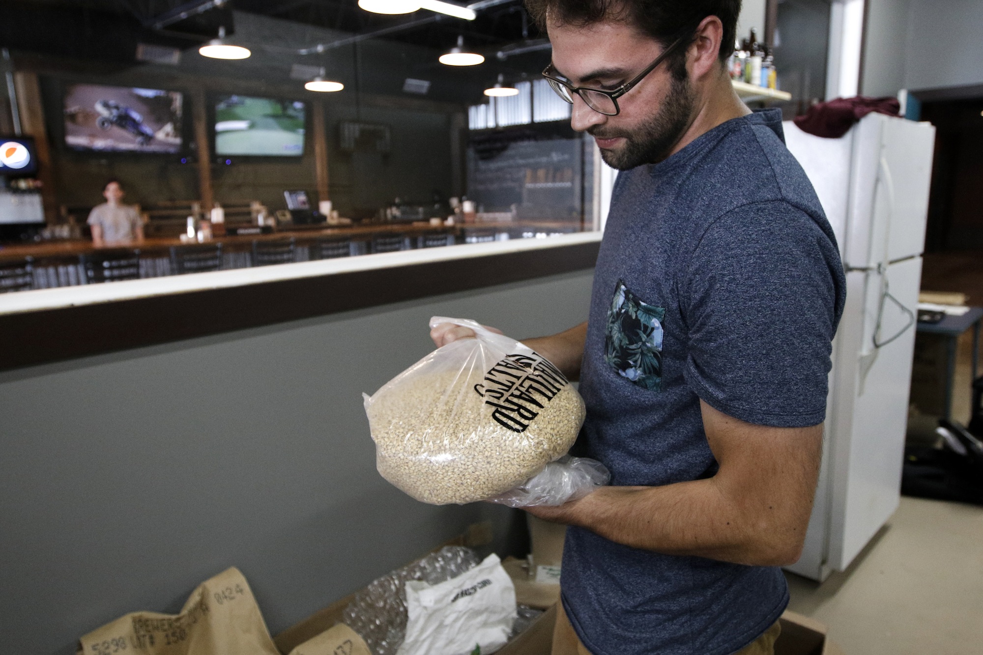 Brewer Kirby Garrison holds a bag of grain for use in brewing Thursday, June 25, 2015, at new brewery Monkey Town Brewing Co. in Dayton, Tenn.