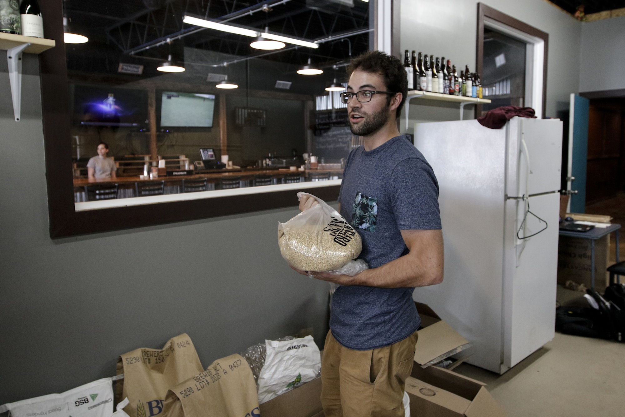 Brewer Kirby Garrison holds a bag of grain for use in brewing Thursday, June 25, 2015, at new brewery Monkey Town Brewing Co. in Dayton, Tenn.