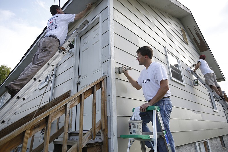 United Way volunteers Steve Kelly, John Rutter and Curtis Crawford, from left, paint a Y-CAP transitional home on Sept. 11, 2014, in Chattanooga, during United Way's Day of Caring.