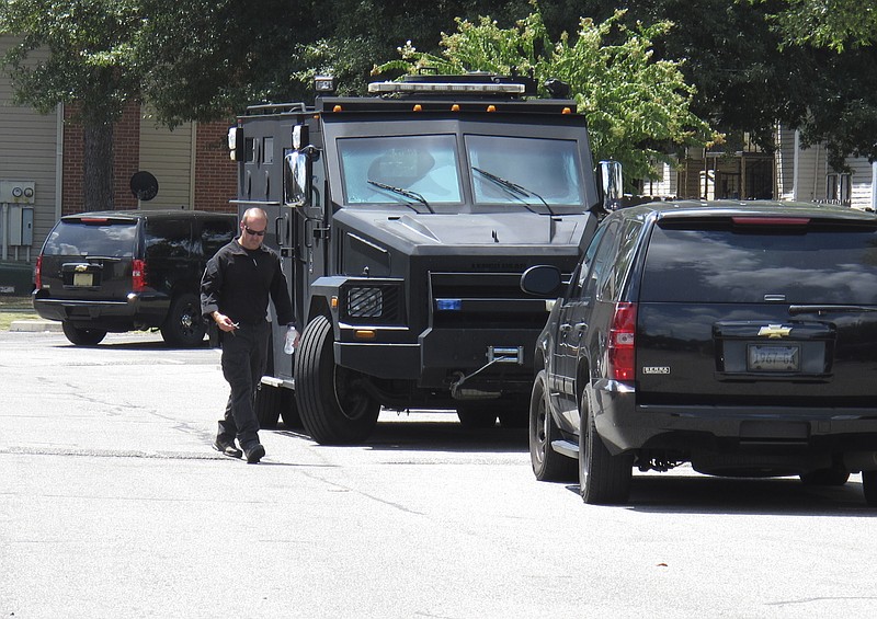 
              A police officer walks by an armored truck during a search of an apartment complex on Sunday, Aug. 2, 2015, in Memphis, Tenn. Police were looking for a suspect in the fatal shooting of Memphis officer Sean Bolton, who was fatally shot Saturday night. (AP Photo/Adrian Sainz)
            