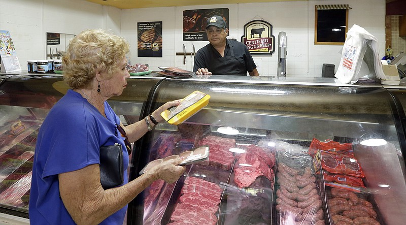 
              In this Friday, June 12, 2015 photo, butcher Jorge Gonzalez, back, waits on a shopper at a local grocery store in the Little Havana area of Miami. The Commerce Department releases its June report on consumer spending, which accounts for 70 percent of economic activity, on Monday, Aug. 3, 2015. (AP Photo/Alan Diaz)
            