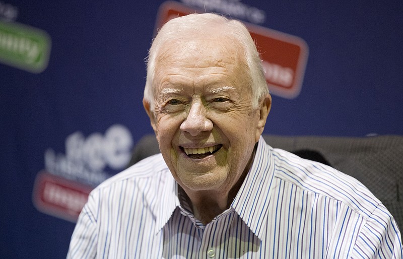 In this July 10, 2015, file photo, former President Jimmy Carter poses for photographs at an event for his new book "A Full Life: Reflections at Ninety at the Free Library in Philadelphia.