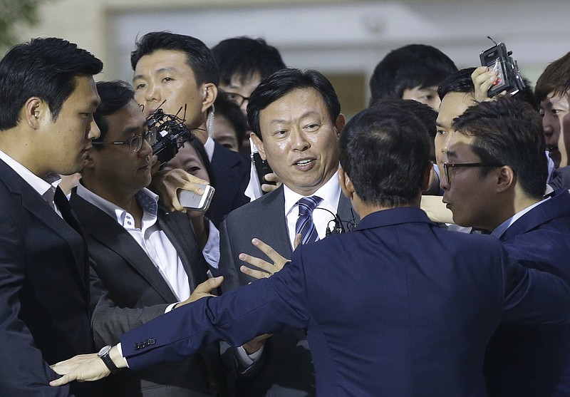 
              Lotte group Chairman Shin Dong-bin, center, is surrounded by the media after a press conference at Gimpo Airport in Seoul, South Korea, Monday, Aug. 3, 2015. Shin, who has been trying to solidify his control of South Korea's largest retailer, which has businesses in South Korea and Japan, in the face of opposition from his older brother Shin Dong-joo, 61, and his father Shin Kyuk-ho, 92, said his brother and father's attempt to sack him as chairman of Lotte had no legal standing. (AP Photo/Ahn Young-joon)
            