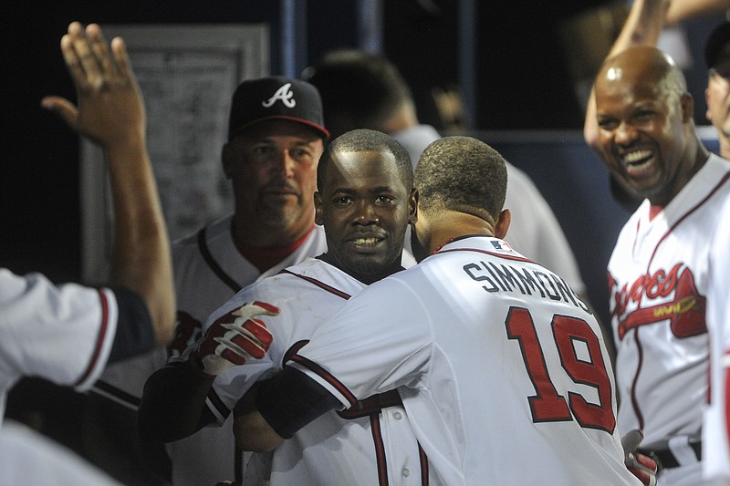 Atlanta Braves' Adonis Garcia, center, is congratulated by shortstop Andrelton Simmons (19) and others as he comes into the dugout after hitting the game winning home-run against the San Francisco Giants during the 14th inning of a baseball game, Monday, August 3, 2015, in Atlanta. Atlanta won 9-8. 