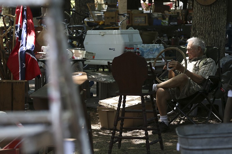 Crickett (this is the sole name he goes by) rests in the shade adjacent to Taft Highway atop Signal Mountain after setting up all of his items for sale on August, 4, 2015 in preparation for this years "Longest Yard Sale."