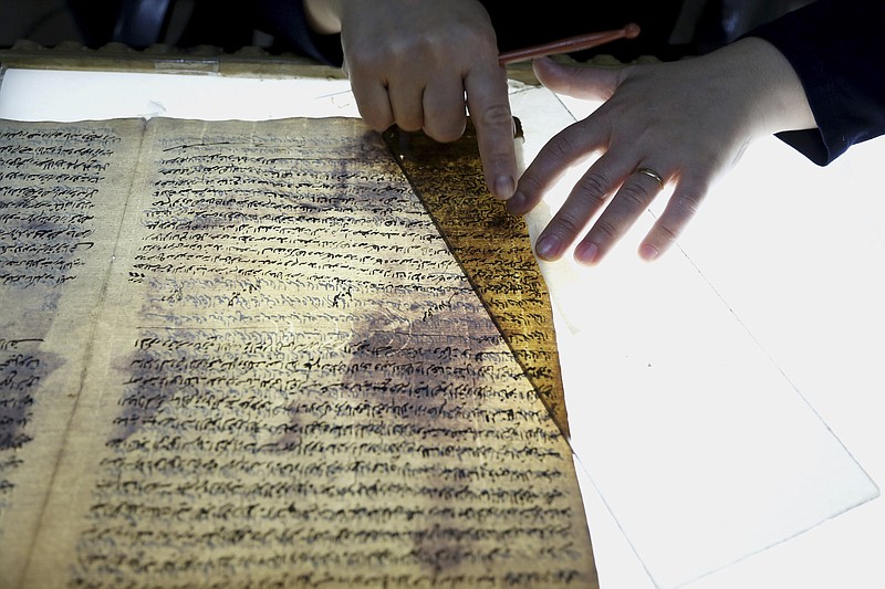 
              In this Tuesday, July 28, 2015 photo, a member of the library restoration staff works on a damaged document at the Baghdad National Library in Iraq. As the Islamic State militants now set out to destroy Iraq's history and culture, including irreplaceable books and manuscripts kept in the militant-held city of Mosul, a major preservation and digitization project is underway in the capital to safeguard a millennia worth of history. (AP Photo/Karim Kadim)
            