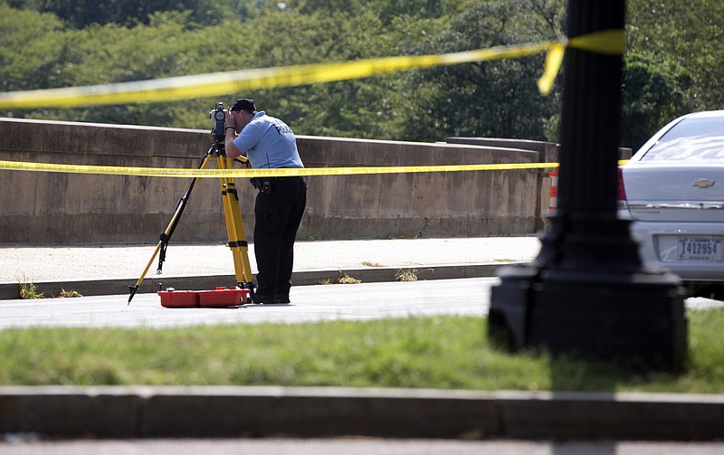 
              Members of the U.S. Park Police investigates the site of a reported shooting near the National Mall in Washington, Tuesday, Aug. 4, 2015. U.S. Park Police say they believe someone fired shots from a vehicle on the National Mal, a broad expanse of parkland in the heart of the U.S. capital.  (AP Photo/Carolyn Kaster)
            