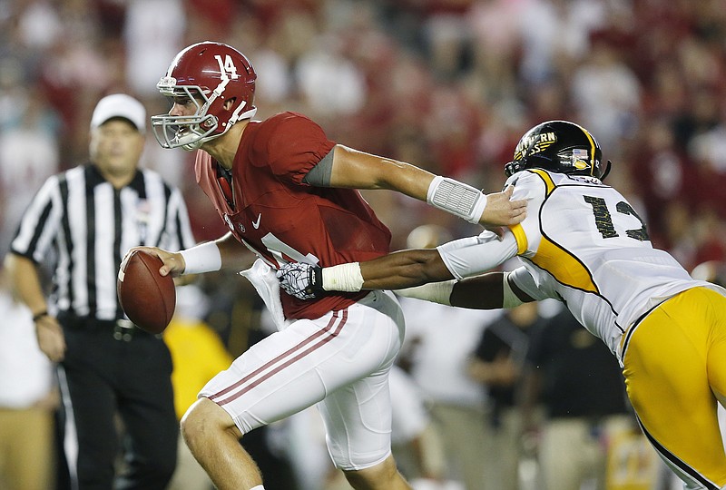 Alabama quarterback Jake Coker (14) pushes Southern Mississippi defensive back Emmanuel Johnson (12) before throwing the ball in the second half of an NCAA college football game Saturday, Sept. 13, 2014, in Tuscaloosa, Ala. (AP Photo/Brynn Anderson)