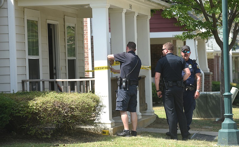 Chattanooga police officers stand outside of a Hughes Avenue home on Tuesday after responding to a call for a 13-year-old male with a gunshot wound to the arm.