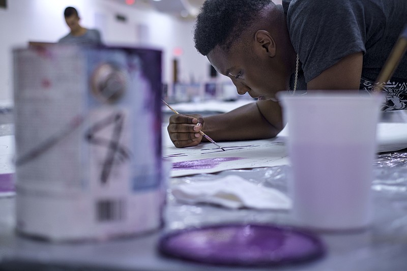 Tyrone Chain fills in paint-by-numbers sections on paper at a public painting session Wednesday, Aug. 5, 2015, on the 4th floor of the Chattanooga Public Library in Chattanooga, Tenn. Painting sessions will be held all month for members of the public who want to assist in painting the 40,000 square foot mural on the exterior of the AT&T Building on Martin Luther King, Jr., Boulevard.