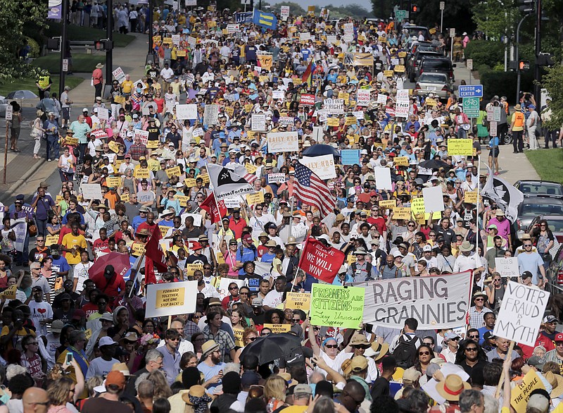 Demonstrators march through the streets of Winston-Salem, N.C., Monday, July 13, 2015 after the beginning of a federal voting rights trial challenging a 2013 state law. 