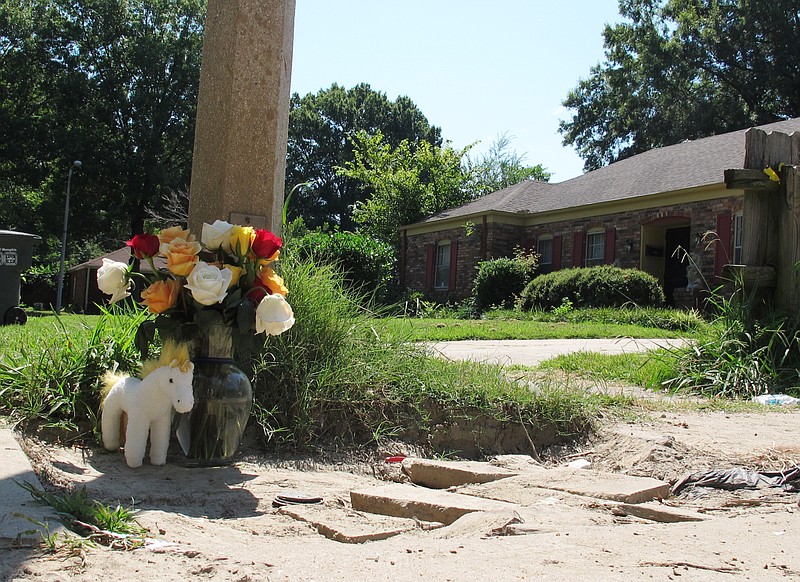 A makeshift memorial rests on the sidewalk Monday, Aug. 3, 2015, at the location where Memphis, Tenn., Police Officer Sean Bolton was fatally shot. Tremaine Wilbourn, the ex-con accused of killing the Memphis Police Officer turned himself into federal authorities Monday, after a two-day manhunt.