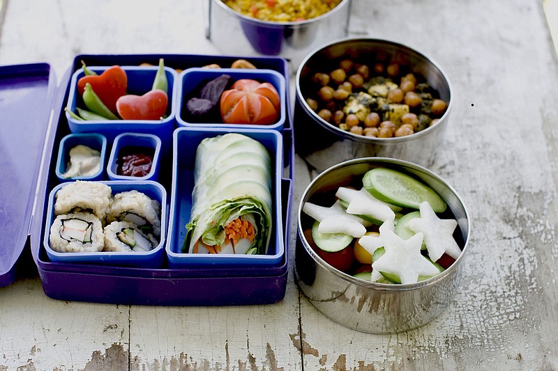 A Japanese bento box and Indian Tiffin offer a multinational version of the traditional brown bag lunch. Today's lunch systems are dominated by bento-style gear, which originated in Japan and involves multiple compartments and containers to hold a variety of foods. And that makes sense for modern kids, who are as likely to be toting sushi and DIY taco kits as they are the classic PB&J. (AP Photo/Matthew Mead, File)
