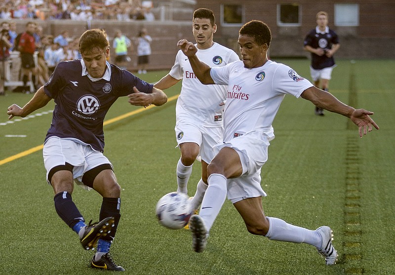 CFC's Jose "Zeca" Ferraz, left, kicks into Cosmos player Daniel Evuy during Chattanooga FC's NPSL national championship match against the New York Cosmos at Finley Stadium on Saturday, Aug. 8, 2015, in Chattanooga, Tenn.