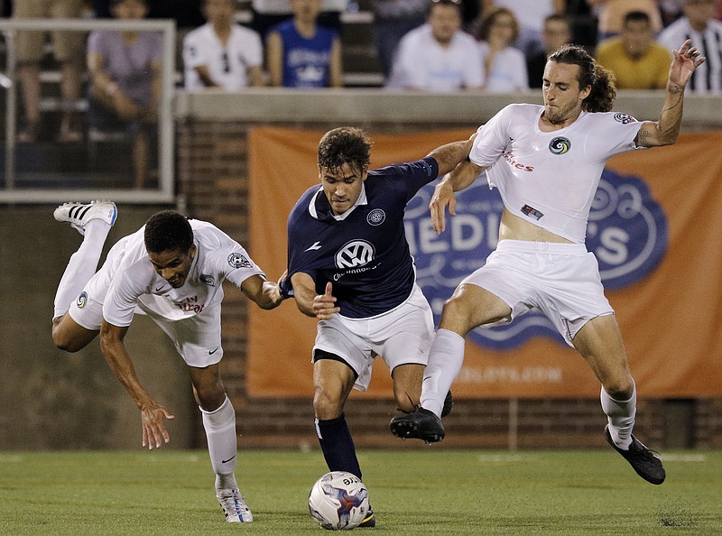 CFC's Luis Trude, center, gets caught between Cosmos players Travis Pittman, right, and Daniel Evuy during Chattanooga FC's NPSL national championship match against the New York Cosmos at Finley Stadium on Saturday, Aug. 8, 2015, in Chattanooga, Tenn.