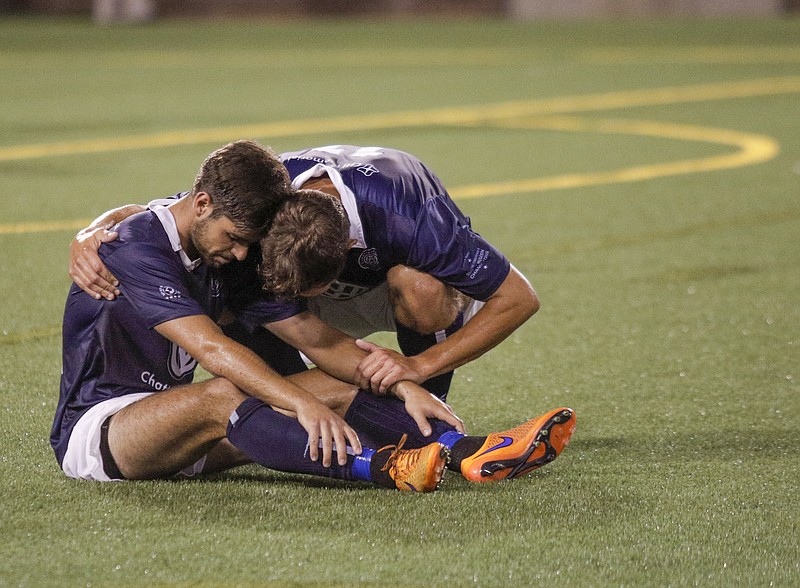 CFC's Sias Reyneke, right, comforts teammate Samuel Goni after Chattanooga FC's NPSL national championship match loss to the New York Cosmos at Finley Stadium on Saturday, Aug. 8, 2015, in Chattanooga, Tenn.