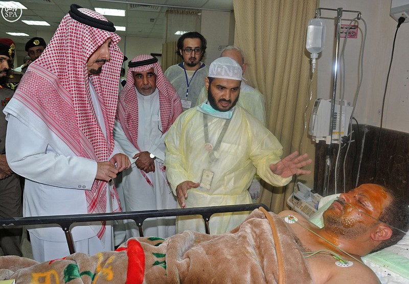 
              In this photo released by the Saudi Press Agency SPA, the governor of Asir, Prince Faisal bin Khaled bin Abdulaziz, left, listens to a doctor, as he visits an injured man, who was wounded in a suicide bombing attack on a mosque inside a police compound, in the city of Abha, the provincial capital of Asir,  Saudi Arabia, Thursday, Aug. 6, 2015. An allegedly new Islamic State affiliate in Saudi Arabia claimed responsibility for a suicide bombing at a mosque inside a police compound in the country's southwest on Thursday that killed several people, most of them members and recruits of the kingdom's special forces. (Saudi Press Agency via AP)
            