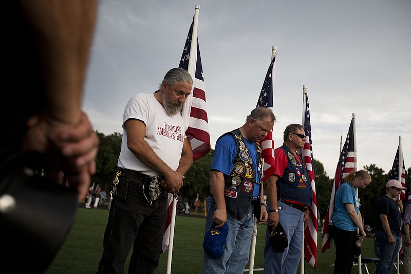 Members of the Patriot Guard Riders observe a moment of prayer during a memorial service for Lance Cpl. Squire Wells, known as "Skip," at Sprayberry High School where he attended on July 21, 2015, in Marietta, Ga. Crowds gathered at the suburban Atlanta high school to remember the Marine who was fatally shot in an attack on military facilities in Chattanooga, Tenn. 