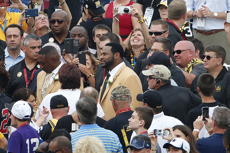 Pro Football Hall of Fame class of 2015 member Jerome Bettis, center, poses for a photo with a fan in the crowd at Tom Benson Hall of Fame Stadium while being introduced during an induction ceremony at the Pro Football Hall of Fame in Canton, Ohio, Saturday, Aug. 8, 2015.