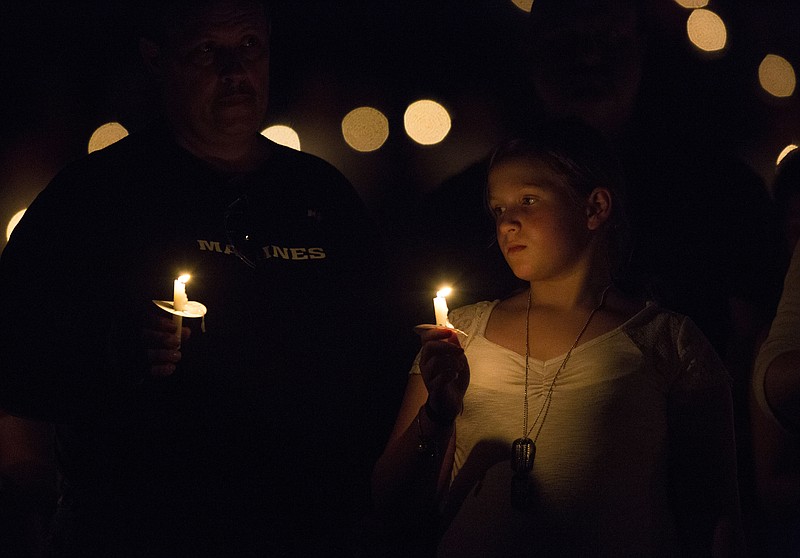 Rebecca Wyatt holds a candle during a vigil for her father Marine David Wyatt August 7, 2015 in Russellville, 	Ark., at Russellville High School. Wyatt was one four military personnel killed in Chattanooga in late July. Family, friends and community members joined at the High School Stadium to honor Wyatt's memory with songs, memories and prayer. 