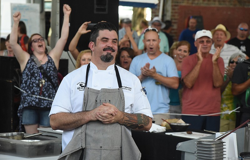 Attendees cheer as chef Eric Fulkerson of the Bald Headed Bistro in Cleveland is named the winner at the FiveStar Food Fight at the Chattanooga Market on Sunday, Aug. 9, 2015, in Chattanooga, Tenn.