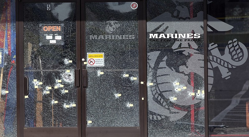 Yellow pieces of paper mark bullet holes in the glass at a military recruiting center on July 17 in Chattanooga.