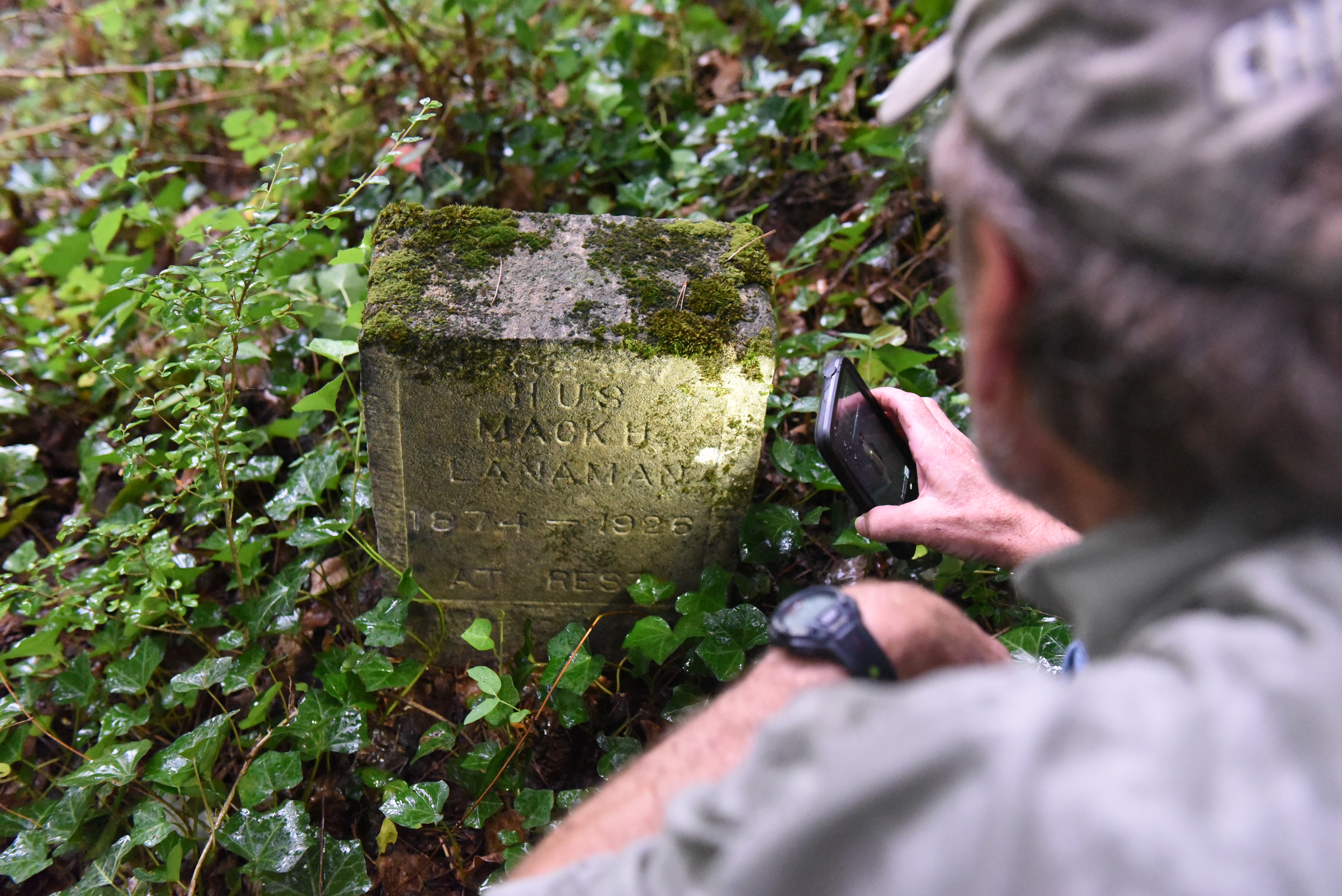 Dr. Nick Honerkamp of the UTC archeology department looks a tombstone at the site of an old cemetery located next to the construction site for a new housing development on Dartmouth Street in the North Chattanooga community Monday, Aug. 10, 2015, in Chattanooga, Tenn.