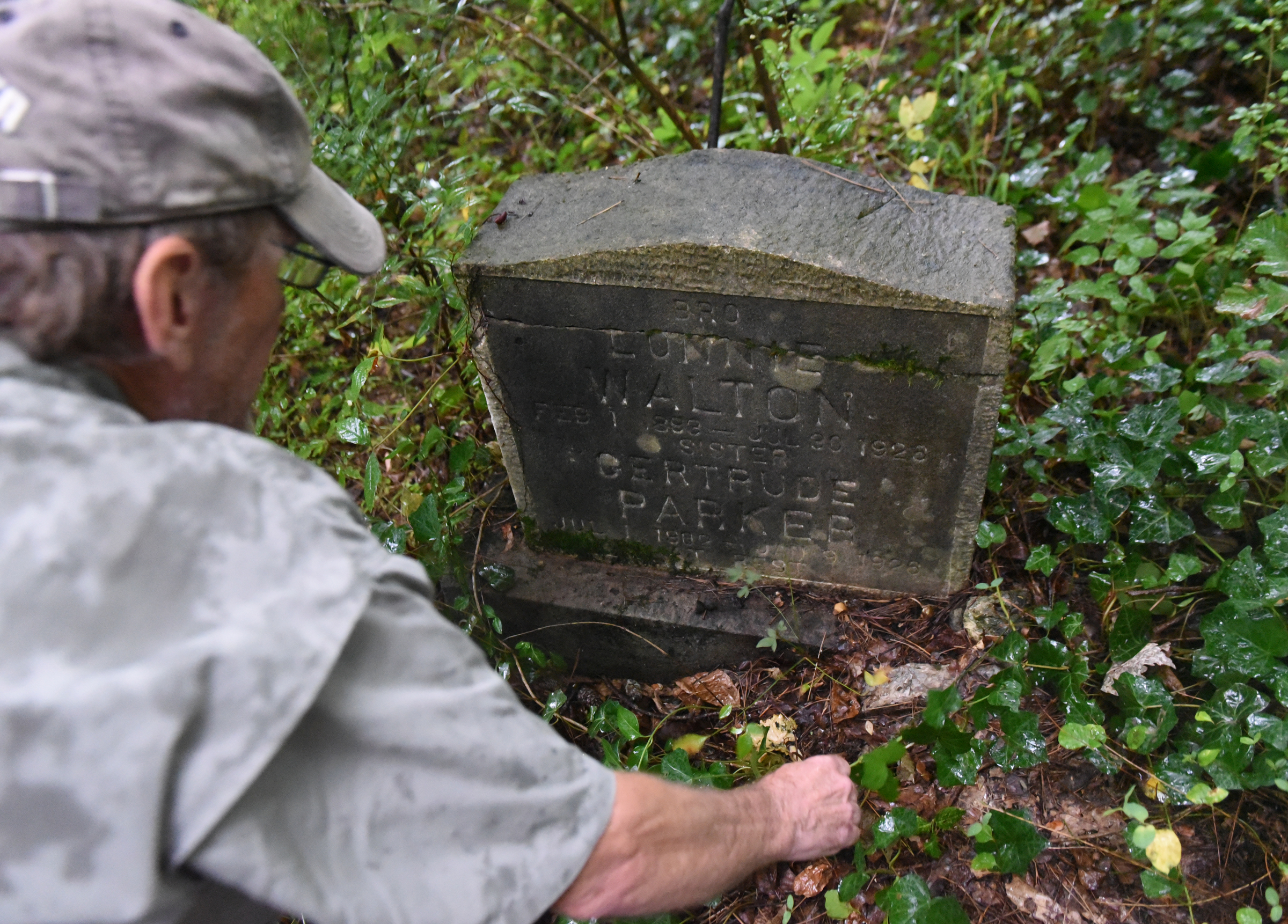 Dr. Nick Honerkamp of the UTC archeology department looks a tombstone at the site of an old cemetery located next to the construction site for a new housing development on Dartmouth Street in the North Chattanooga community Monday, Aug. 10, 2015, in Chattanooga, Tenn.