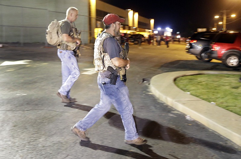 Heavily armed civilians with a group known as the Oath Keepers arrived in Ferguson, Mo., early Tuesday. St. Louis County Police Chief Jon Belmar said the overnight presence of the militia and far-right activist group — wearing camouflage bulletproof vests and openly carrying rifles and pistols on West Florissant Avenue, the hub of marches and protests for the past several days — was "both unnecessary and inflammatory." (AP Photo/Jeff Roberson)