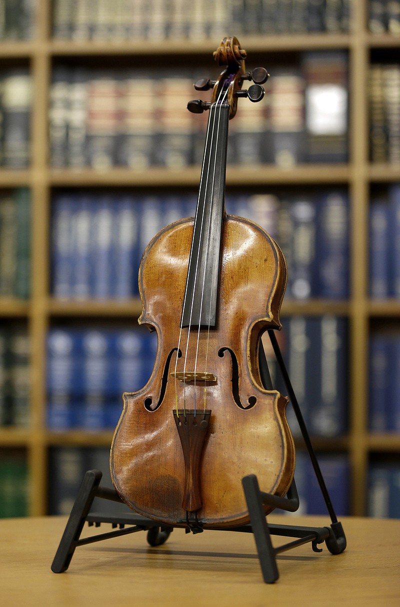 
              FILE - In this Aug. 6, 2015, photo, the Ames Stradivarius violin is displayed during a news conference in New York. The instrument was stolen from renowned violinist Roman Totenberg 35 years ago. Philip Johnson was dying of pancreatic cancer when he brought his former wife, Thanh Tran, to the basement of his home in Venice, Calif., and showed her a violin inside a case with a combination lock. He gave the violin to Tran. He didn’t tell her anything about it, and she didn’t ask. It wasn’t until nearly four years later that Tran learned the truth: The case contained a famous Stradivarius that had been stolen from Totenberg in 1980, most likely by Johnson. (AP Photo/Seth Wenig, File)
            