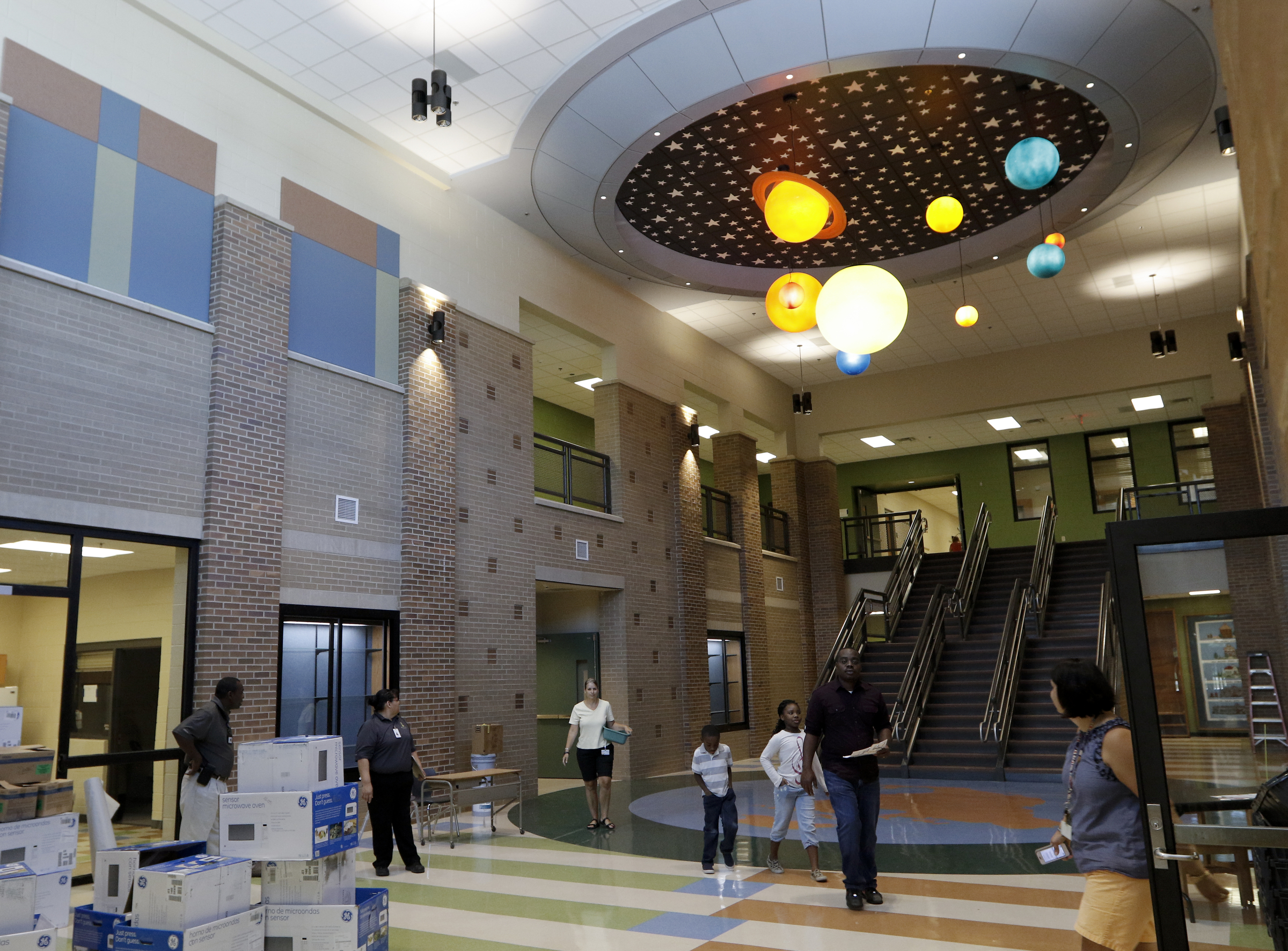 People gather in the entrance hall Wednesday, Aug. 12, 2015, at the new East Brainerd Elementary School in Chattanooga, Tenn. Thursday is Hamilton County's first day of school.