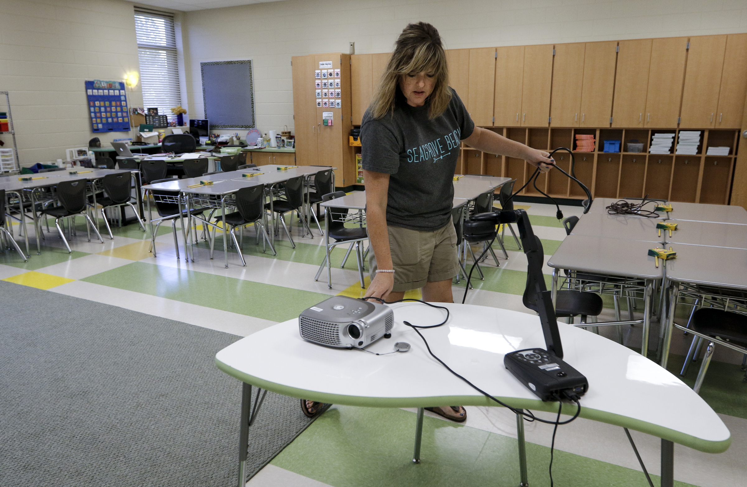 Second grade teacher Valorie Bowers sets up a projector in her classroom while preparing for the first day of school Wednesday, Aug. 12, 2015, at the new East Brainerd Elementary School in Chattanooga, Tenn. Thursday is Hamilton County's first day of school.