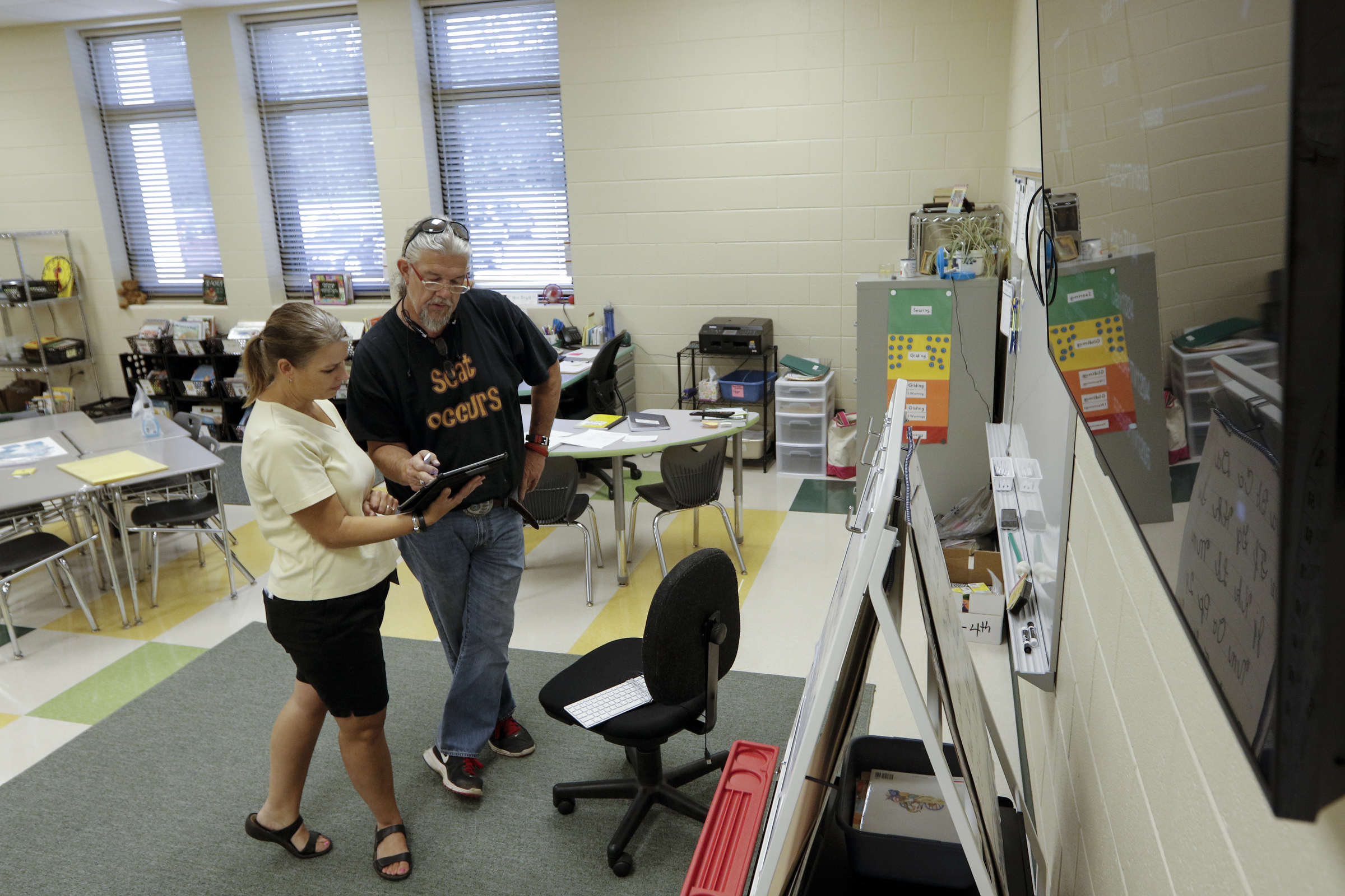 Second grade teachers Amy Ingell, left, and Jody Conn set up a television on the wall of Ingell's classroom Wednesday, Aug. 12, 2015, at the new East Brainerd Elementary School in Chattanooga, Tenn. Thursday is Hamilton County's first day of school.